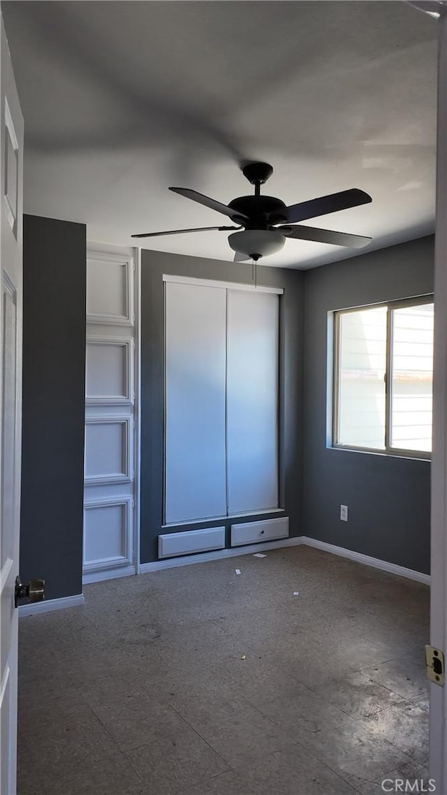 unfurnished bedroom featuring baseboards and ceiling fan