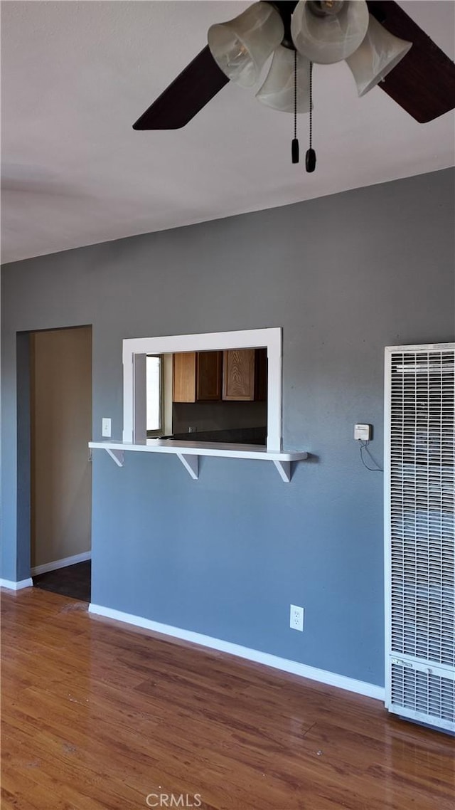 spare room with a heating unit, baseboards, and ceiling fan