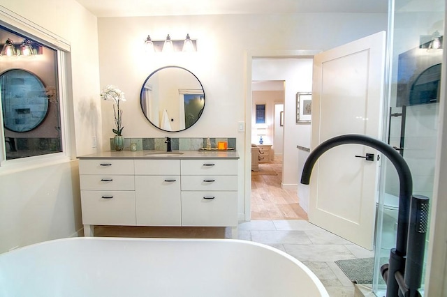 full bathroom featuring a freestanding tub and vanity