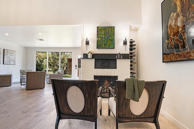 dining room featuring recessed lighting, wood finished floors, visible vents, baseboards, and a brick fireplace