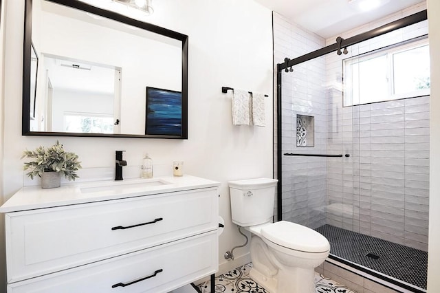 bathroom with toilet, a stall shower, baseboards, and vanity