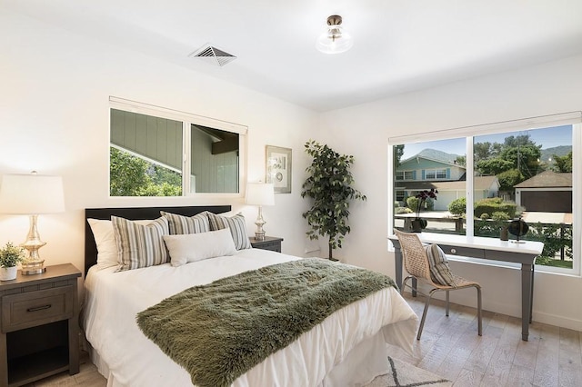 bedroom featuring light wood-style floors and visible vents