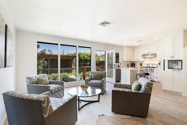 living room featuring recessed lighting, visible vents, and light wood finished floors