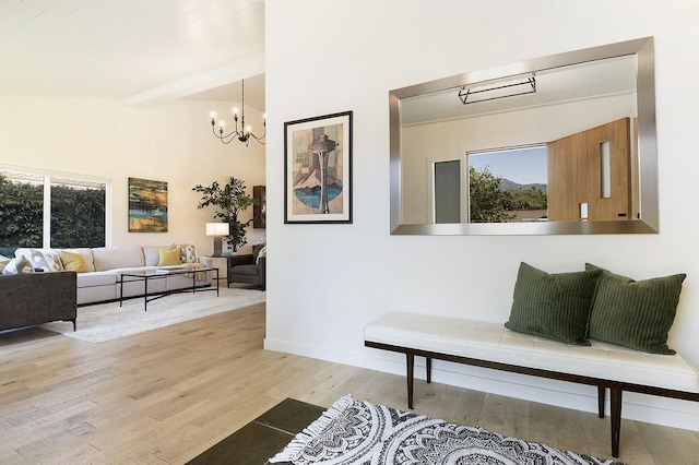 hall featuring light wood-type flooring, an inviting chandelier, baseboards, and beam ceiling