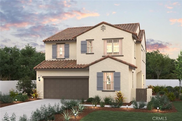 mediterranean / spanish house with stucco siding, concrete driveway, an attached garage, fence, and a tiled roof