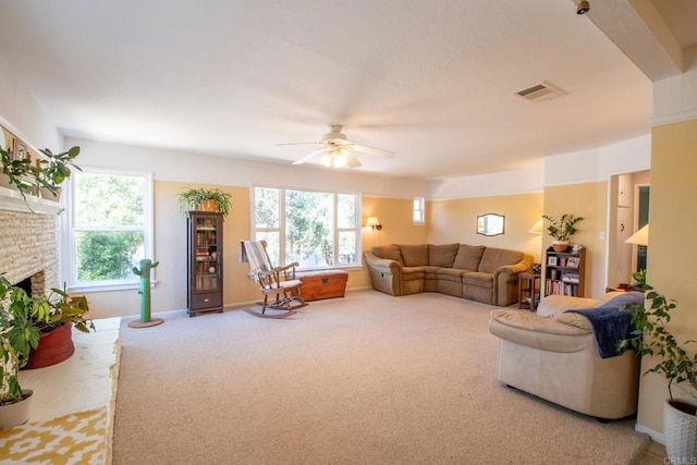 living room featuring a healthy amount of sunlight, a fireplace, visible vents, and carpet flooring