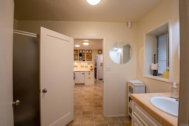 full bath with baseboards, vanity, and tile patterned floors