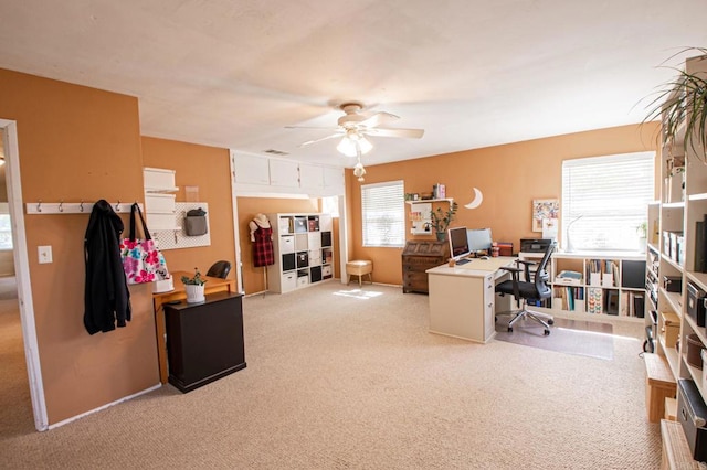 carpeted office space featuring a healthy amount of sunlight, visible vents, and a ceiling fan