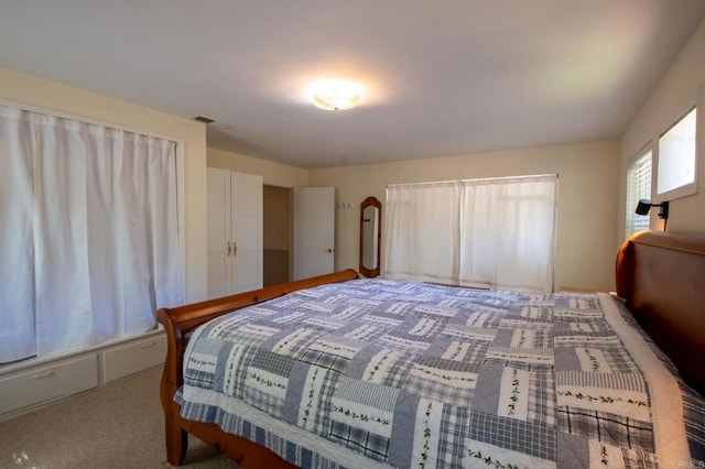 carpeted bedroom featuring visible vents