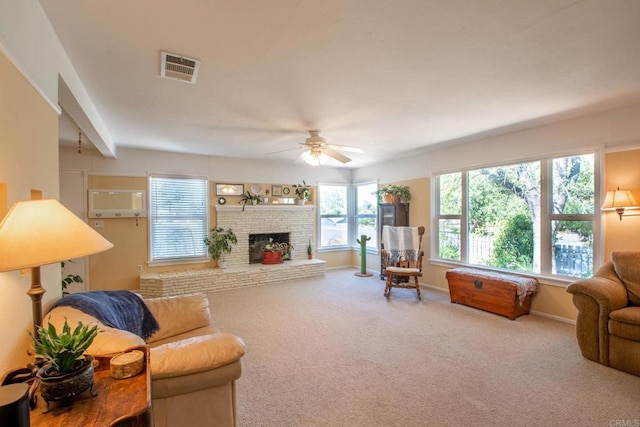 living area with a fireplace, visible vents, carpet flooring, ceiling fan, and baseboards