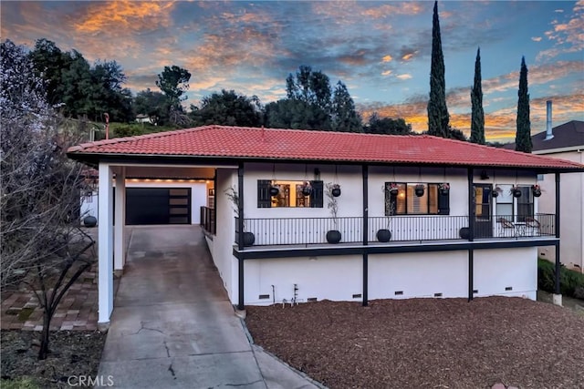 view of front of home with a tile roof, stucco siding, an attached garage, crawl space, and driveway