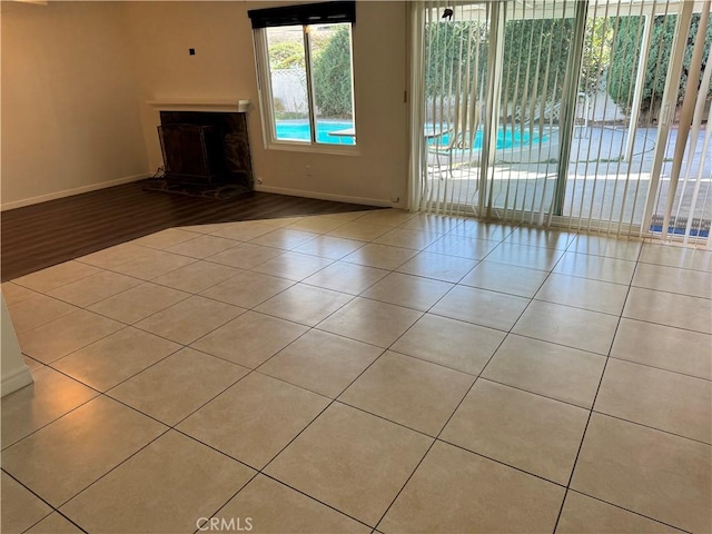 unfurnished living room with tile patterned flooring and baseboards