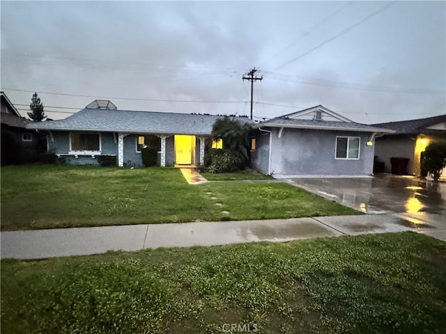 ranch-style house featuring driveway and a front lawn