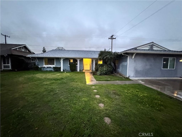 single story home featuring driveway, a front lawn, and stucco siding