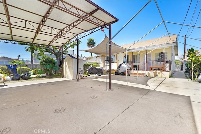 view of patio with an outdoor structure, a storage unit, and fence