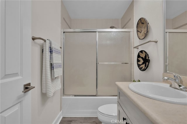 full bathroom featuring enclosed tub / shower combo, toilet, wood finished floors, and vanity