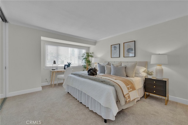 bedroom featuring ornamental molding, light carpet, and baseboards