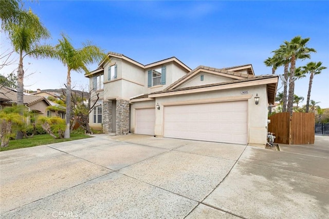 traditional home with fence, concrete driveway, and stucco siding