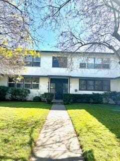 view of front facade with a front lawn and stucco siding