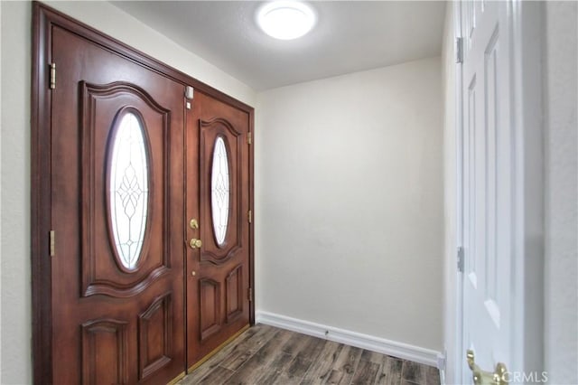 foyer with dark wood-style floors and baseboards