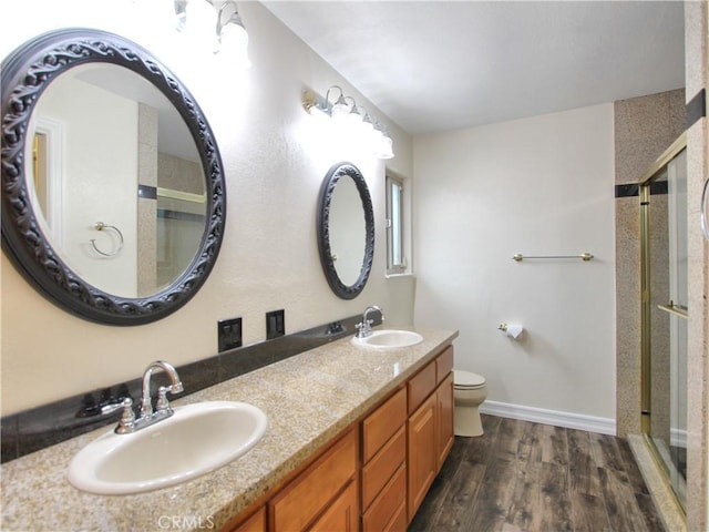 full bath with a stall shower, a sink, and wood finished floors