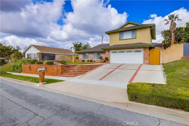 traditional home with concrete driveway, brick siding, fence, and an attached garage