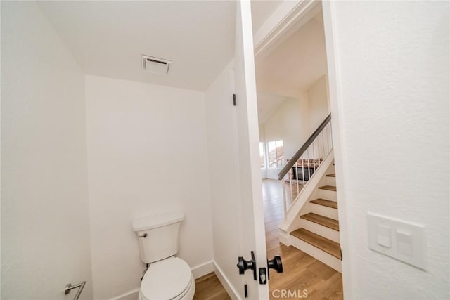 bathroom featuring baseboards, visible vents, toilet, and wood finished floors