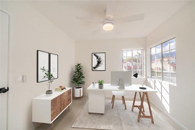 office area with ceiling fan and baseboards