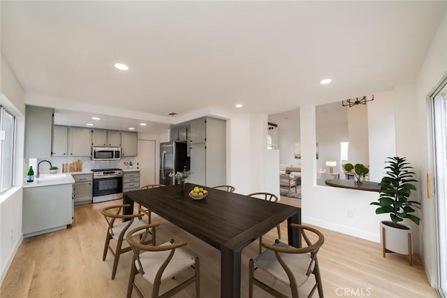 dining space with light wood-style flooring, baseboards, and recessed lighting