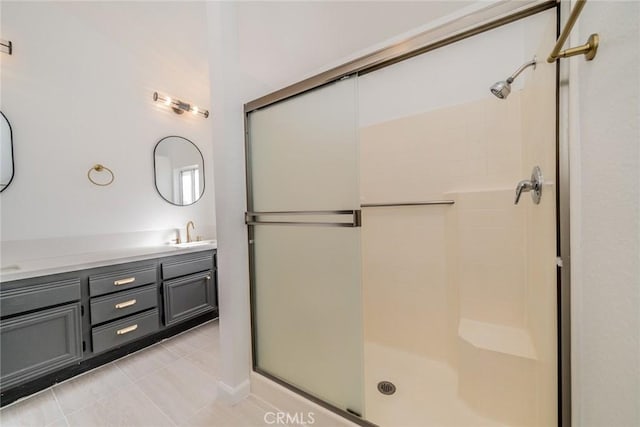 full bathroom with double vanity, a shower stall, a sink, and tile patterned floors