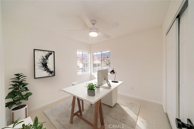 office with light carpet, baseboards, and a ceiling fan