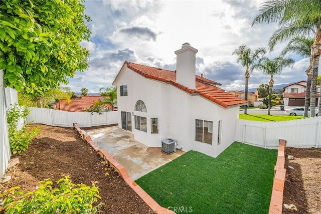 back of house with stucco siding, a fenced backyard, a yard, and a patio