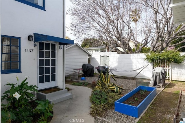 view of yard with entry steps, a vegetable garden, and fence