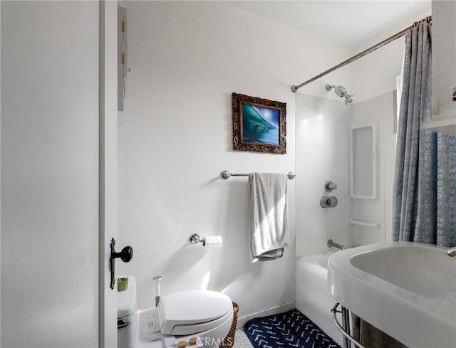 bathroom featuring shower / bath combination, a sink, toilet, and baseboards