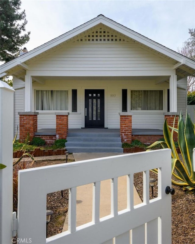 bungalow-style house with a porch and brick siding