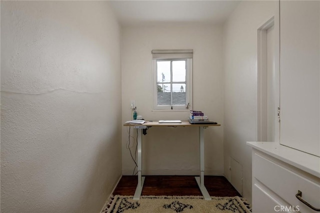 unfurnished office with wood finished floors and a textured wall