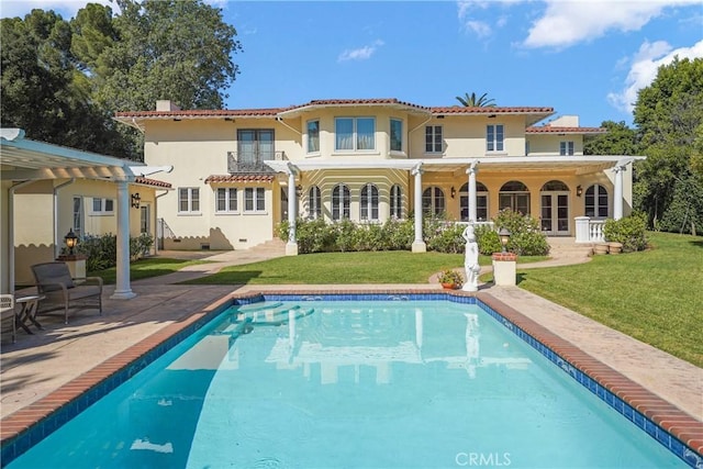 back of property featuring french doors, stucco siding, a lawn, a pergola, and an outdoor pool