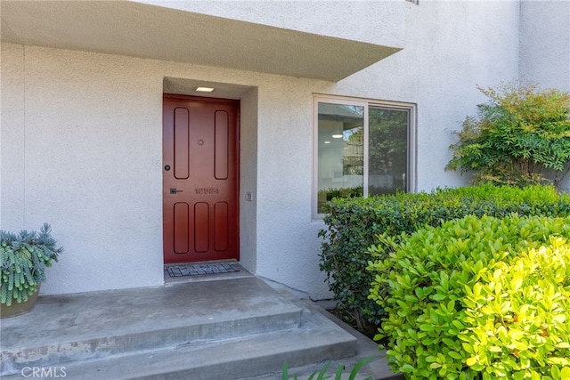 view of exterior entry with stucco siding