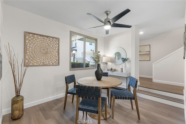 dining space featuring a ceiling fan, baseboards, and wood finished floors