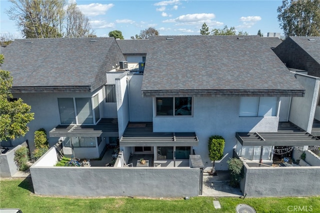 back of property featuring a shingled roof, a patio, and stucco siding