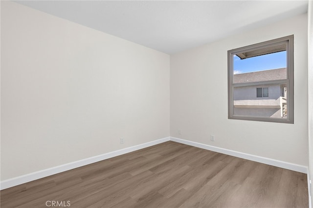 unfurnished room featuring baseboards and wood finished floors