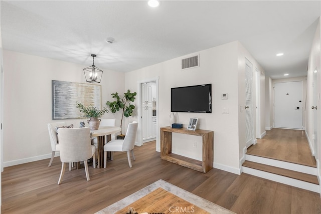 dining room with baseboards, visible vents, wood finished floors, a chandelier, and recessed lighting