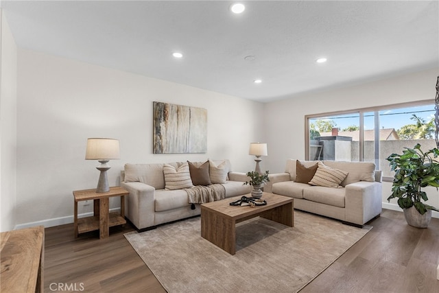 living room featuring baseboards, light wood-style flooring, and recessed lighting