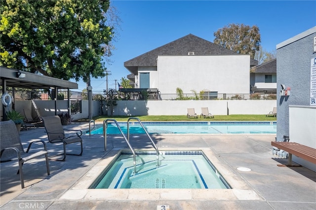 view of pool with an in ground hot tub, a patio area, fence, and a fenced in pool