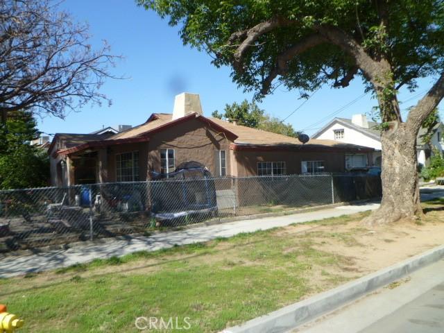 view of side of home with a fenced front yard and a chimney