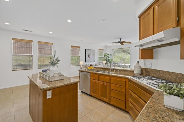 kitchen featuring visible vents, stainless steel dishwasher, a sink, plenty of natural light, and under cabinet range hood