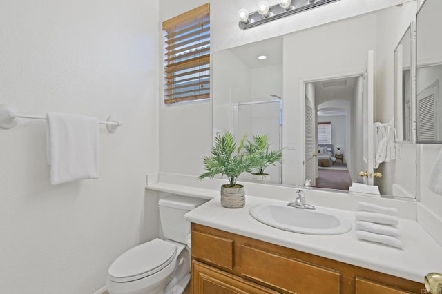 bathroom with a shower with door, vanity, and toilet