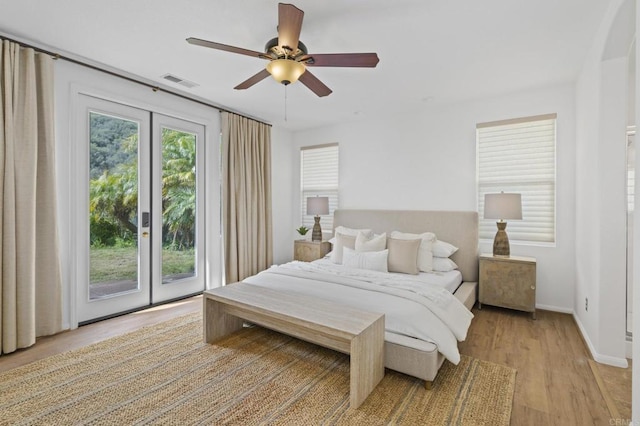 bedroom with ceiling fan, visible vents, baseboards, light wood-style floors, and access to exterior