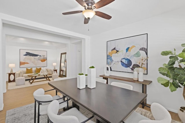 dining area with ceiling fan, light wood finished floors, and baseboards