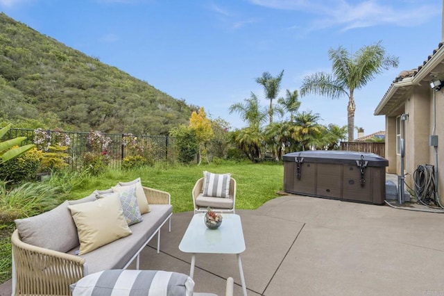 view of patio featuring a hot tub, outdoor lounge area, and a fenced backyard